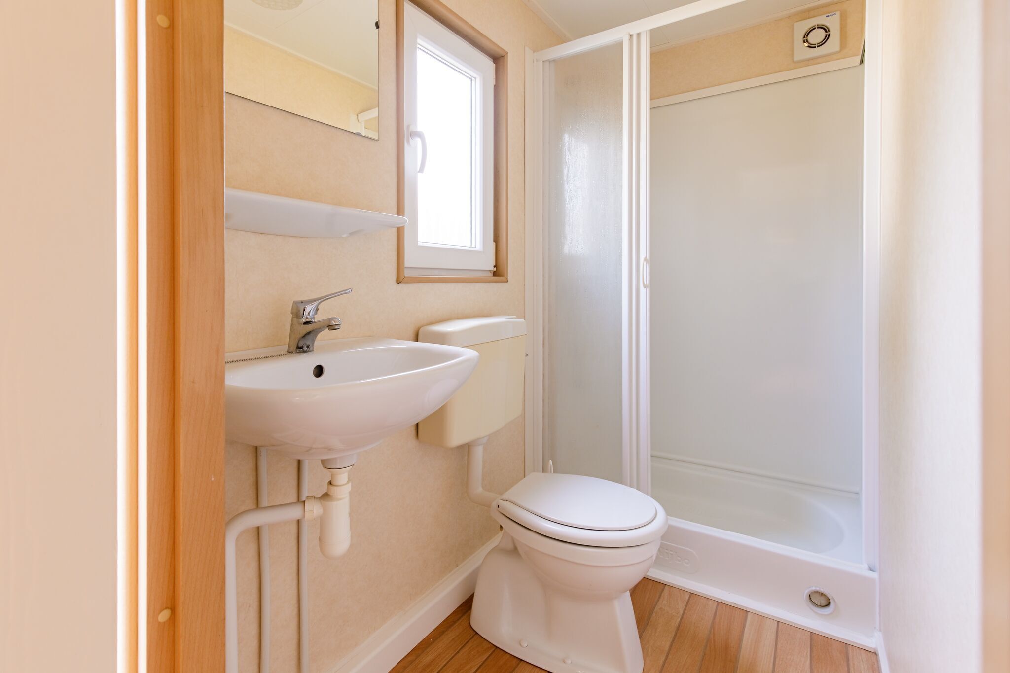 A bathroom with a white sink, toilet, and shower.