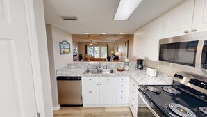 A modern kitchen with a granite countertop, stainless steel appliances, and a dishwasher.