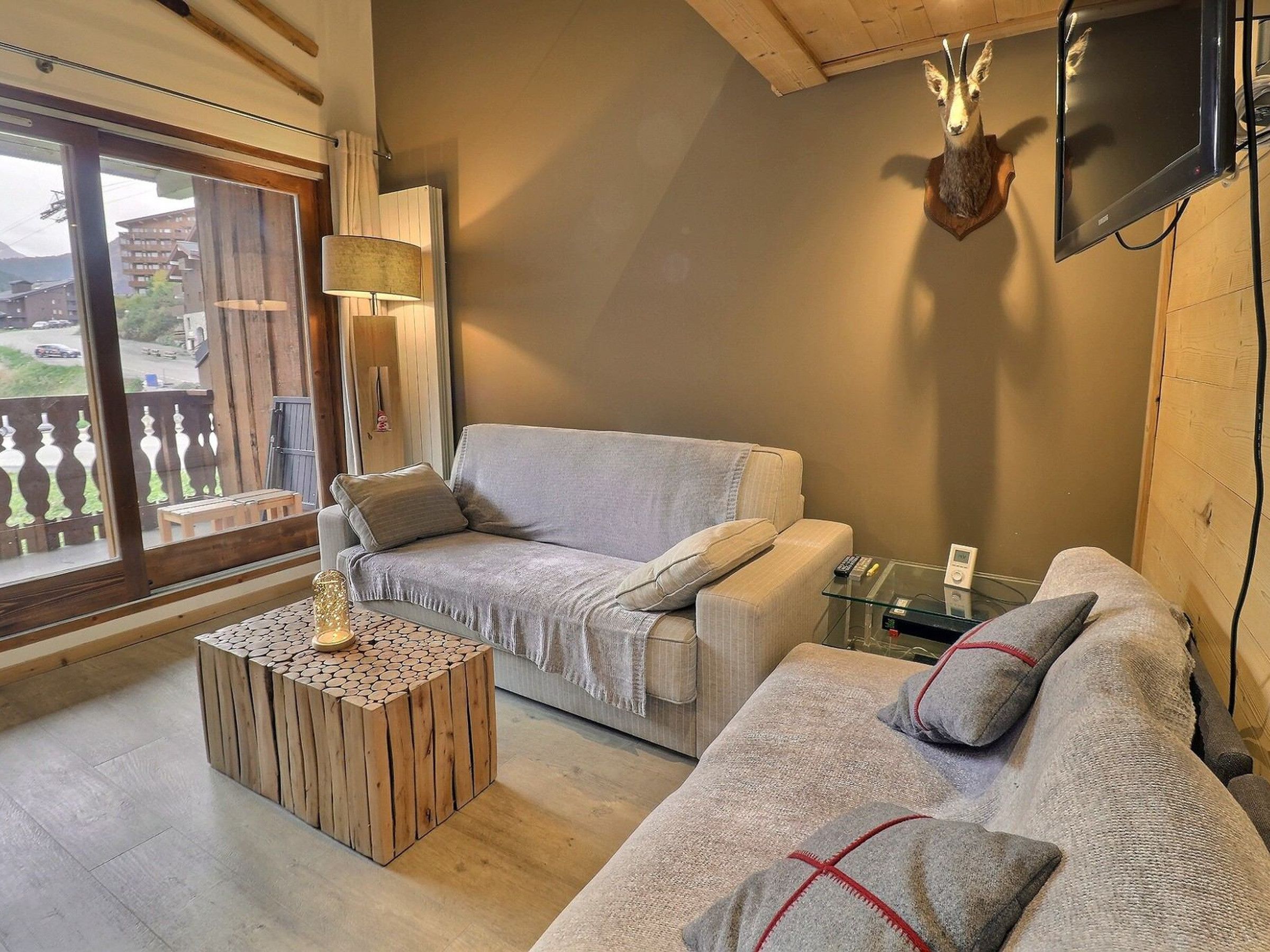 A cozy living room with a sofa, a coffee table, and a mounted TV.