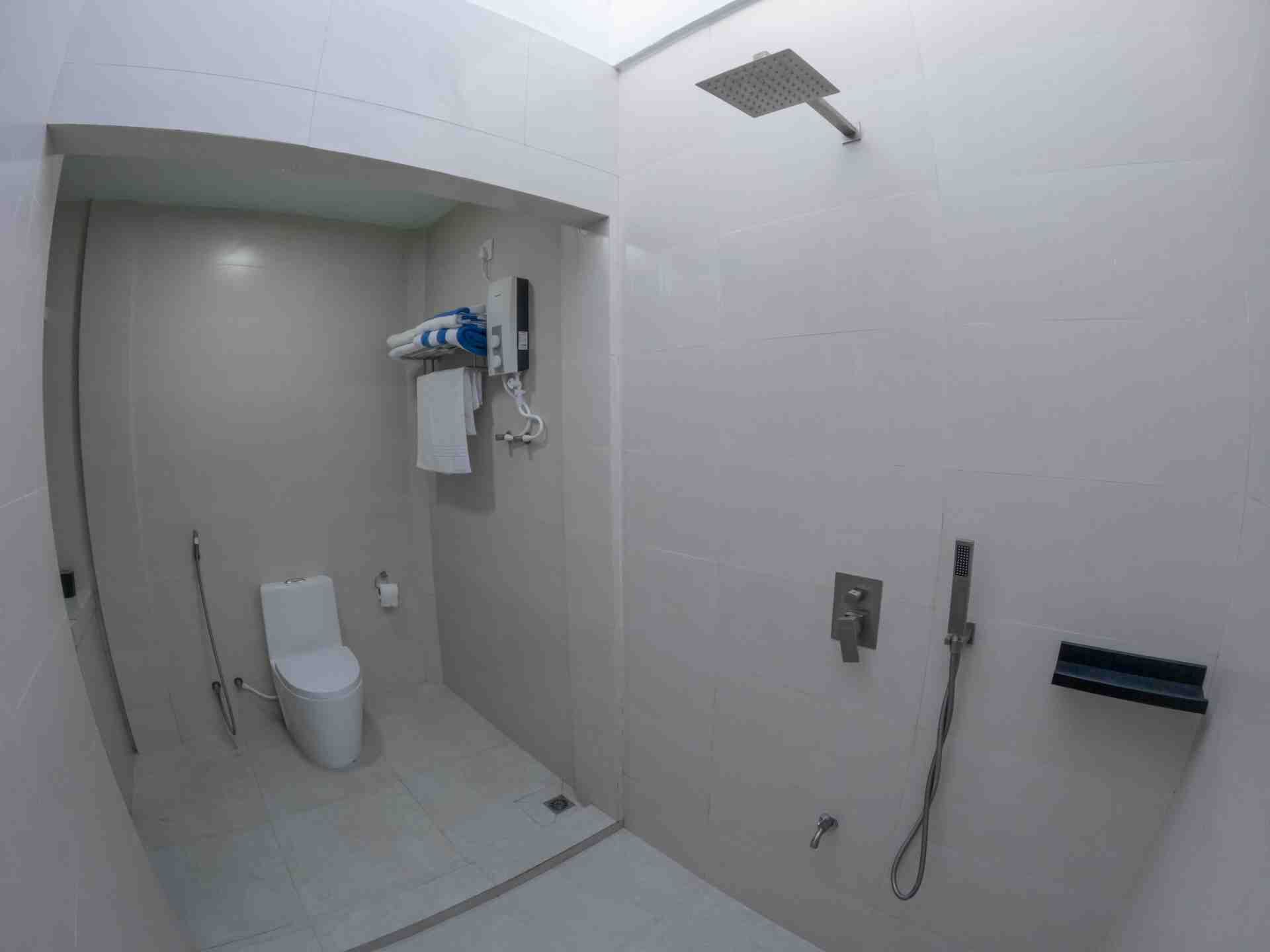 Ein modernes Badezimmer mit Dusche, Toilette und Handtuchhalter.