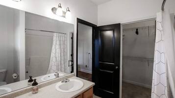 Een bad/douchecombinatie, een haardroger, zeep, shampoo