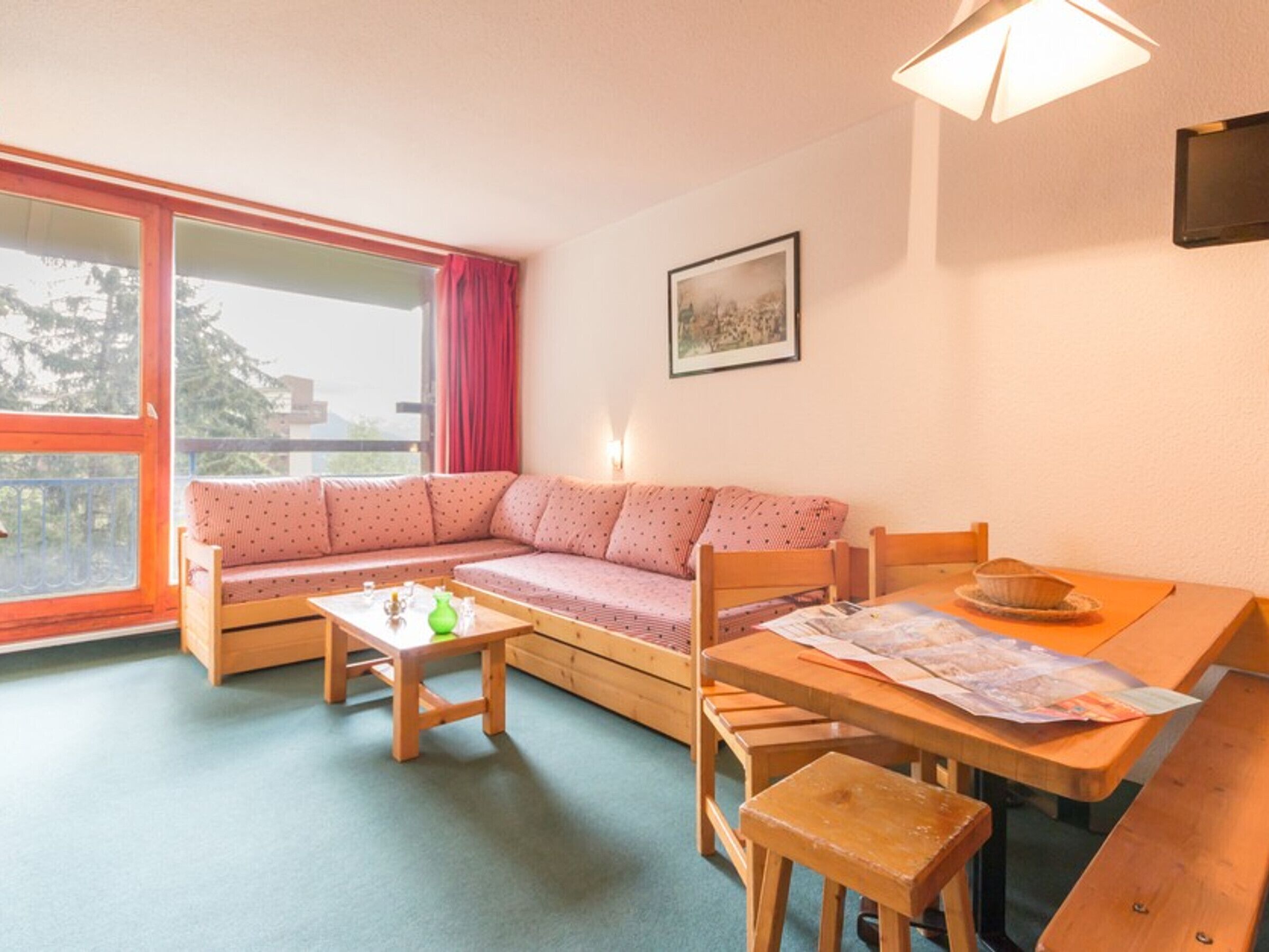 Ett mysigt vardagsrum med en soffa, ett träbord och ett matbord.