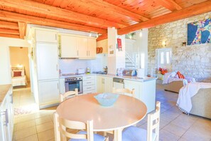 Enjoy meals in the spacious kitchen area with oven and dishwasher, then dine at the central dining table.