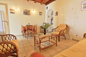 Enjoy meals in this inviting dining area with a table for two, a vase with flowers, and a framed picture on the wall.