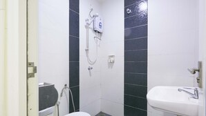 A bathroom with a toilet, a sink, and a shower with a handheld showerhead. - Orange Hotel Kuala Pilah (Kuala Pilah)