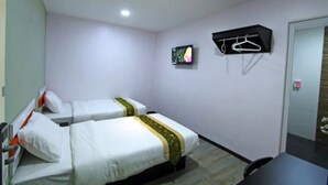 A hotel room with two beds, a TV, a coat rack, and a desk. - Orange Hotel Kuala Pilah (Kuala Pilah)