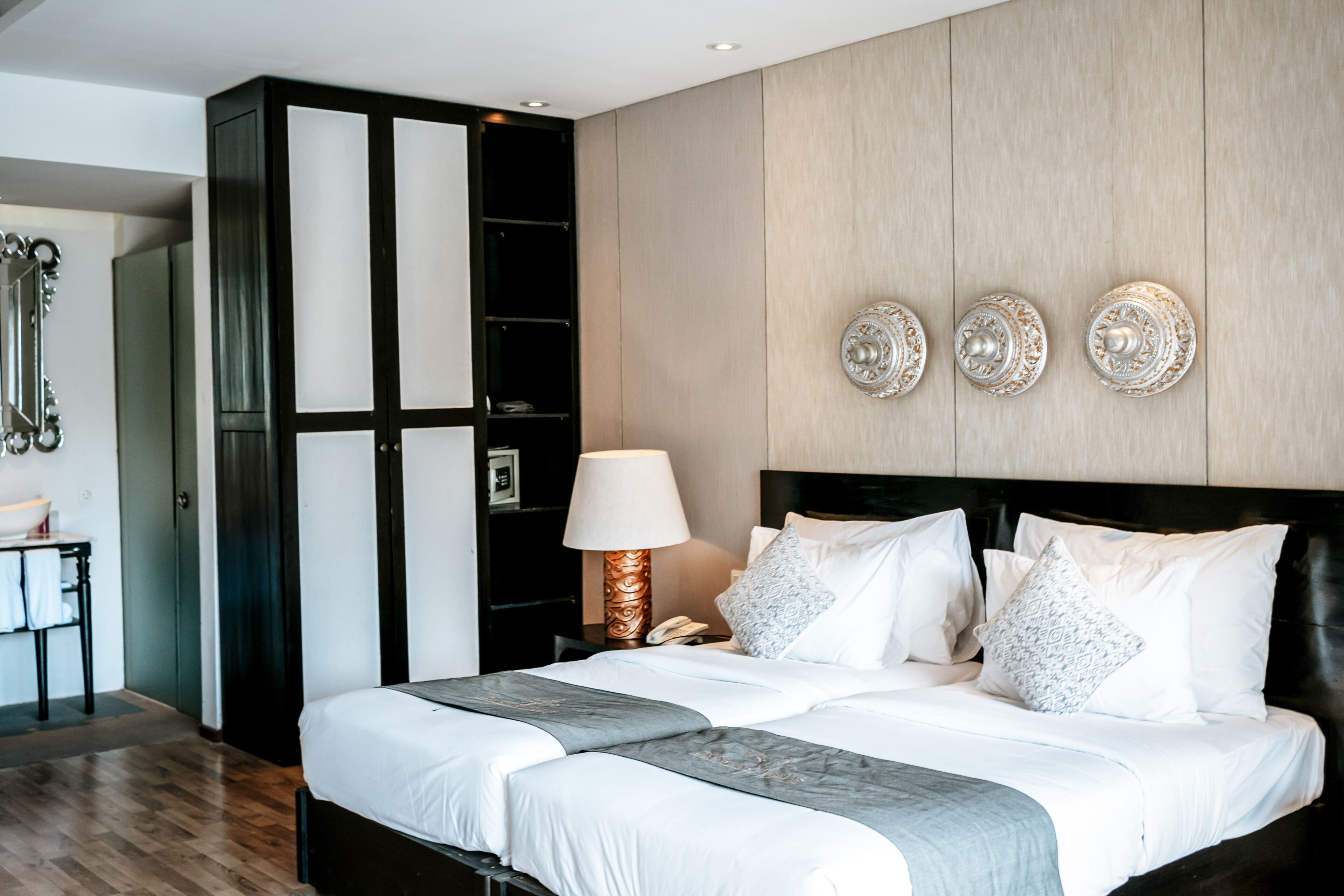 Ein modernes Hotelzimmer mit einem großen Bett, einem Nachttisch, einer Lampe und dekorativen Wandplatten.