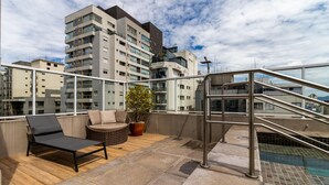 A rooftop terrace with a pool, lounge chairs, and a potted plant. - Iquali013 Akile Homes Apto (São Paulo)