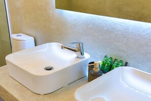 A bathroom with two sinks, a toilet, and a bottle of hand soap. - Senses Suite Dio in Dassia (Corfu)