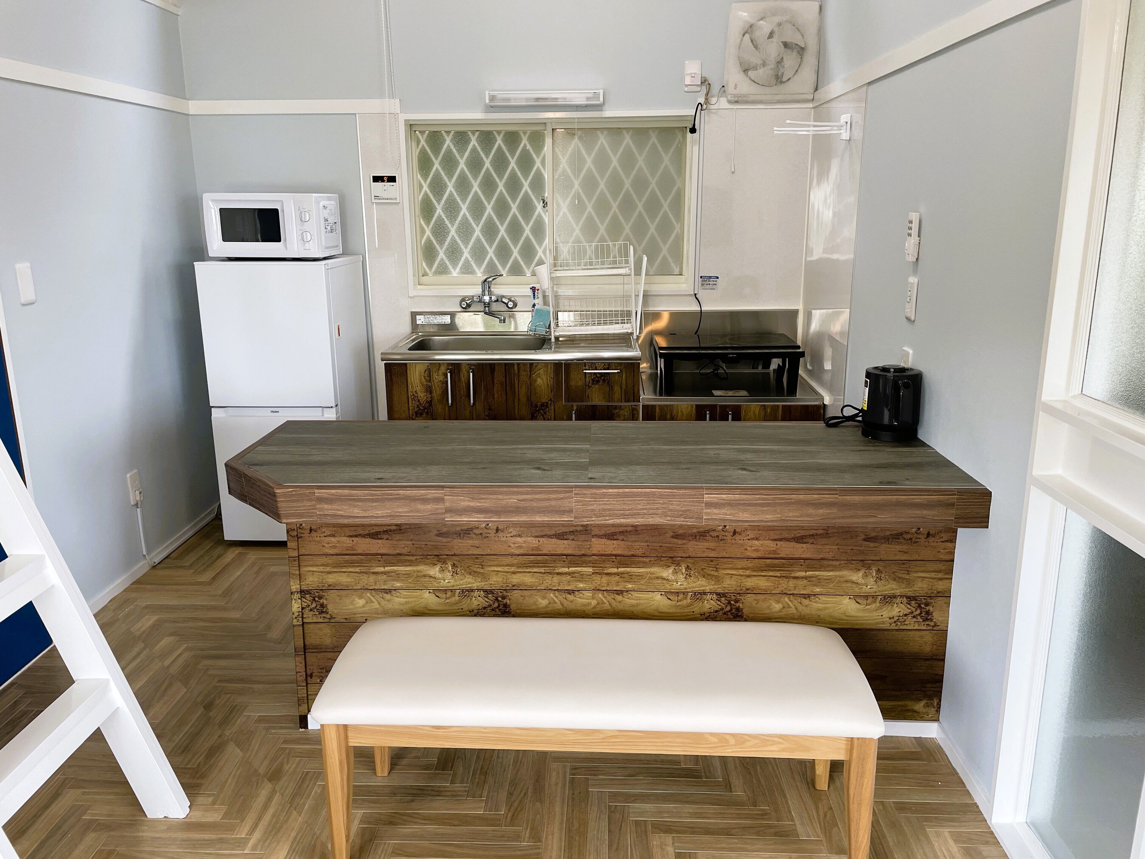 Una cocina compacta con encimera de madera, un banco integrado y un microondas.