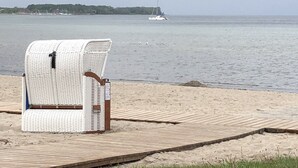 A beach chair on a wooden boardwalk by the sea. - Modern spacious house with 3 bedrooms, garden and barbecue. Beach only 700m! (Zierow)
