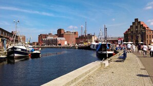 A harbor with boats docked, a cobblestone walkway, and historic buildings in the background. - Modern spacious house with 3 bedrooms, garden and barbecue. Beach only 700m! (Zierow)