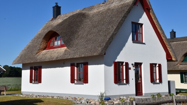 A traditional house with a thatched roof, white walls, and red shutters. - Modern spacious house with 3 bedrooms, garden and barbecue. Beach only 700m! (Zierow)