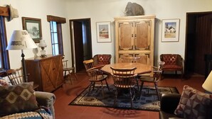 Un coin repas avec une table et des chaises en bois, un buffet et un tapis à motifs.