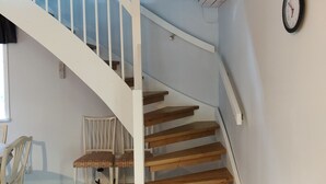 A wooden staircase with white railings leading to a second floor.