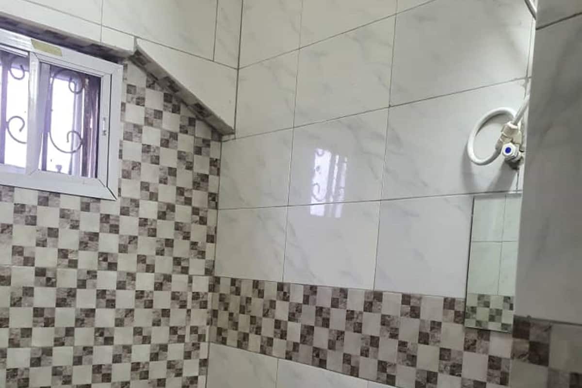 A small bathroom with a toilet, bidet, and tiled walls.