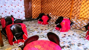 A room with a patterned floor, red-covered chairs, and a central table with a red tablecloth. - Oak Valley Hotel & Event Center (Port Harcourt)