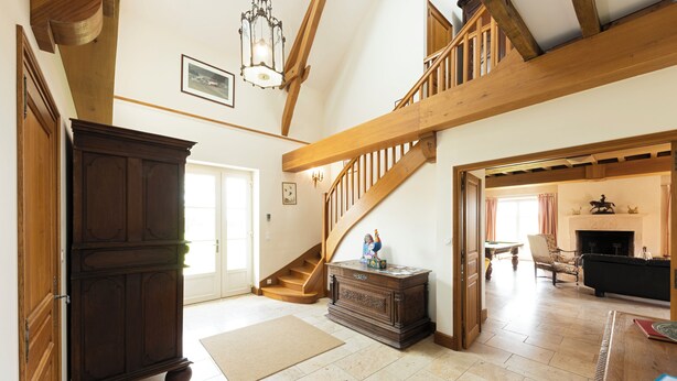 A spacious living area with a wooden staircase, a fireplace, and a large wooden cabinet. - Spacious house, private pool, 10 to 15 p. (Chémery)