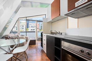 Enjoy meals in the kitchen with a sleek oven and sink, then dine at the glass table.