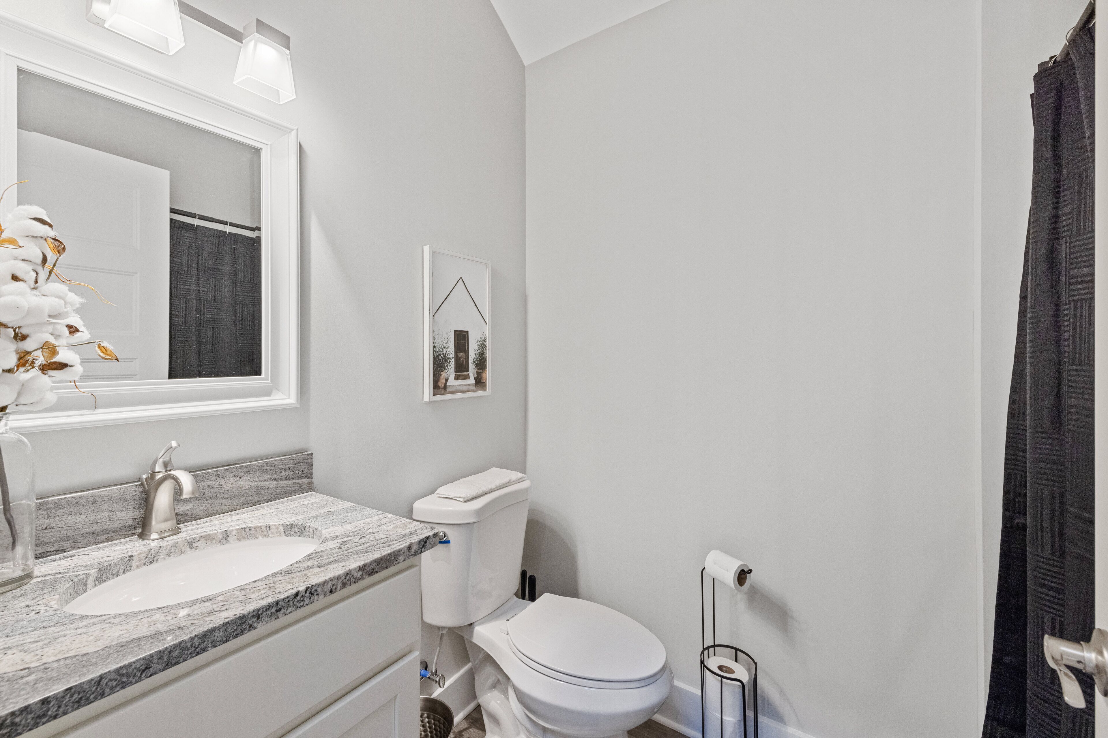 Ein Badezimmer mit weißem Waschbecken, Toilette und Duschvorhang.