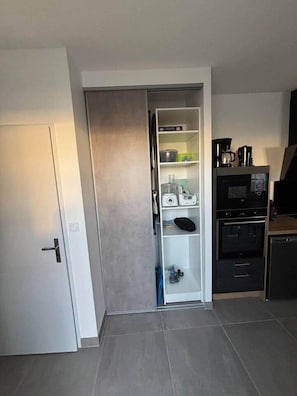Eine moderne Küche mit Einbauofen, Mikrowelle und Kaffeemaschine.