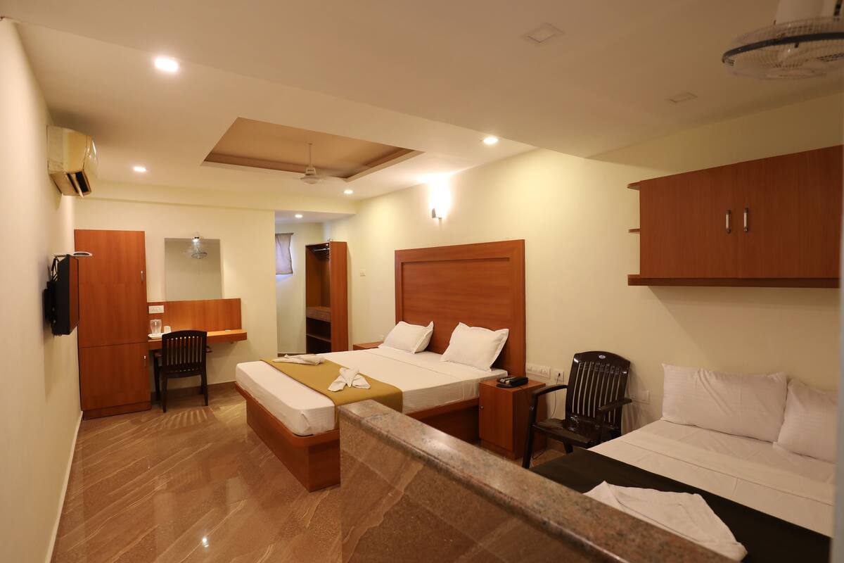 A hotel room with a bed, a desk, a chair, a wardrobe, and a bathroom.