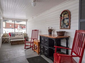 A cozy room with a wooden bench, red chairs, a small table with a kettle, and a wall-mounted sign. - Bethel Village Retreat (Bethel)