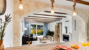 Una sala de estar moderna con una mesa de madera, una chimenea y vistas al área exterior.