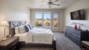 A bedroom with a bed, dresser, and a ceiling fan. - 4 En Suites on the 18th - Perfect for Golf Groups (Saint George)