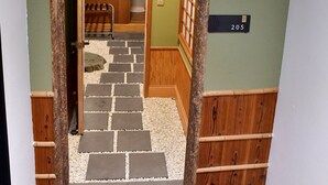 A traditional Japanese-style entrance with a wooden archway, a stone pathway, and a sign indicating room number 205. - Villa 33 Kashikojima (Shima)