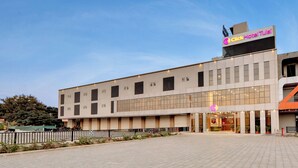 Un moderno edificio de hotel con un letrero llamativo que dice 'Click Hotel Tulsi'.
