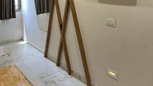 Una sala de estar moderna con un televisor montado en la pared, vigas de madera y un estante empotrado.