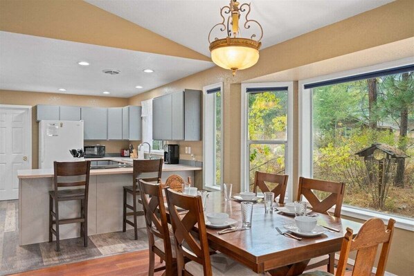 A modern kitchen with a dining area, large windows, and a view of the outdoors. - 3BR Retreat | Hot Tub, Pool Table & Foosball | Near Golf & Leavenworth (Leavenworth)