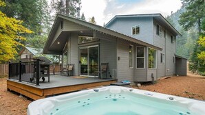 Et toetagers hus med terrasse, jacuzzi og en overdækket patio.