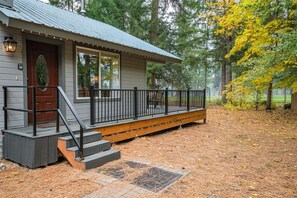 A cabin with a porch, steps, and a door.