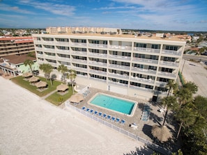 Un hôtel à plusieurs étages doté de balcons, d’une piscine et d’un accès à la plage.