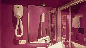 A bathroom with a pink sink, a toilet, a mirror, and a shower. - Diana (Lucca)