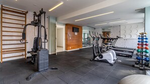A gym with exercise equipment including a squat rack, treadmills, and a weightlifting station. - Av0203 Studio Avanhandava (São Paulo)