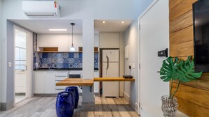 A modern kitchen with a wooden countertop, a white refrigerator, and a blue tiled backsplash. - Av0203 Studio Avanhandava (São Paulo)