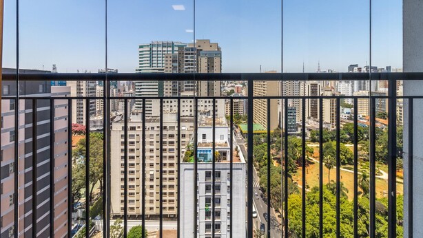 A high-rise building with multiple floors, large windows, and a view of a cityscape through a glass barrier. - Ycp1903 in S o Paulo (São Paulo)