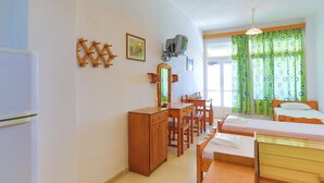 A bedroom with a bed, a desk, a chair, a wardrobe, and a television. - Faros Dio Gaios Studio sea Views Private Sun-loungers (Paxos)
