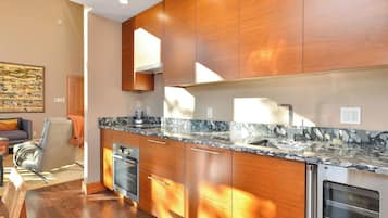 Une cuisine moderne avec des meubles en bois, un plan de travail en marbre et des appareils électroménagers intégrés.