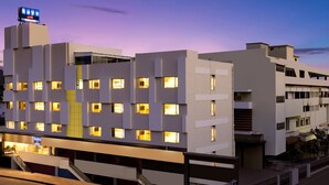 A modern hotel with multiple floors, a prominent sign, and a staircase leading to the entrance. - Keys Lite Sreekanya Visakhapatnam (Visakhapatnam)