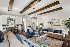 A spacious living area with a sofa, a coffee table, and a dining area with a kitchen in the background. - Full Downtown Luxury Vacation Home AND Guest Home (West Palm Beach,)