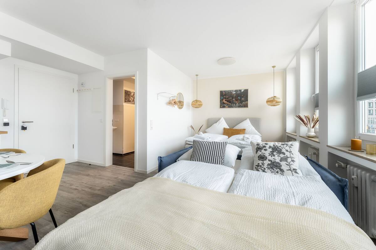 Um quarto moderno com uma cama, mesas de cabeceira, uma escrivaninha e uma cadeira.