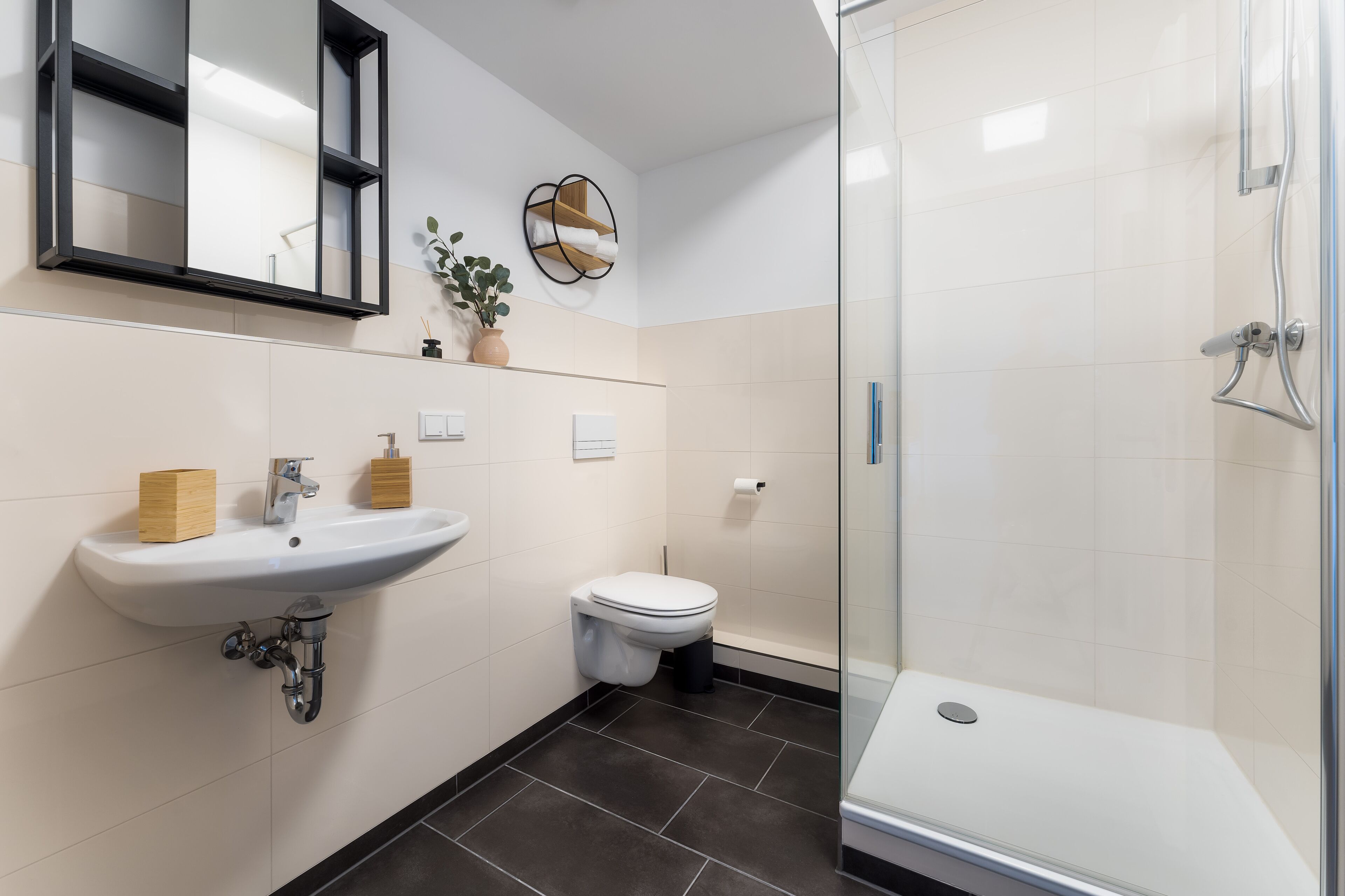 Ein modernes Badezimmer mit Waschbecken, Toilette und einer Duschkabine.