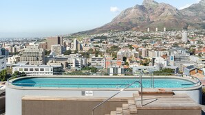 A rooftop pool with a "No Diving" sign, surrounded by a cityscape with buildings and mountains in the background. - FortyOnL 610 (Cape Town)