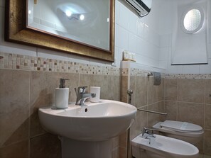 Ein Badezimmer mit Waschbecken, Toilette und Spiegel.