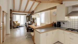 Una cocina moderna con vigas de madera, un comedor y una sala de estar.