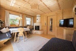 Un intérieur de chalet chaleureux avec une cheminée, une table à manger et un téléviseur.